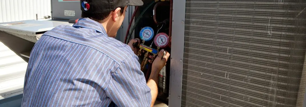 HVAC technician servicing a condenser unit in Newberry