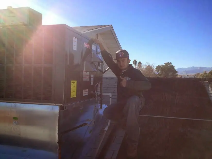 HVAC technician performing Air Duct Repair on a rooftop unit in Newberry